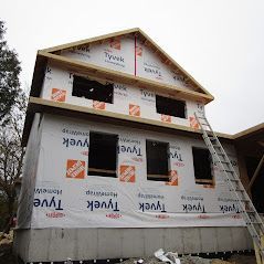 A house is being built with a ladder on the side of it.