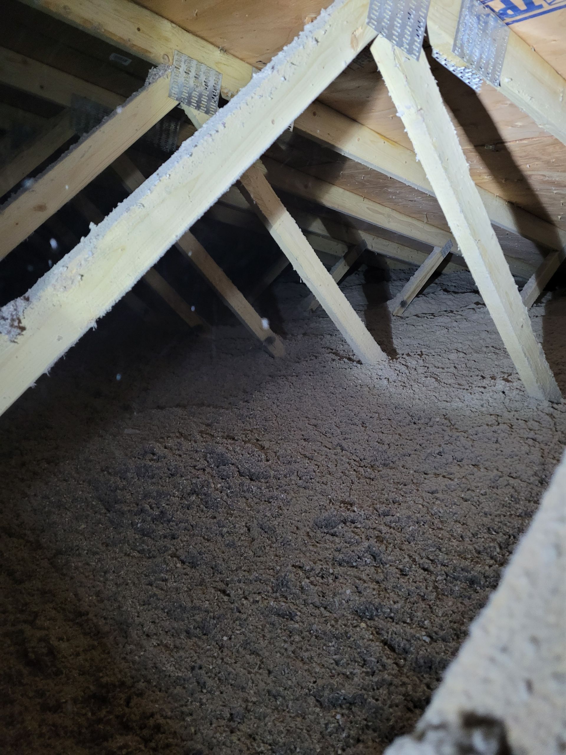 There is a lot of insulation in the attic of a house.