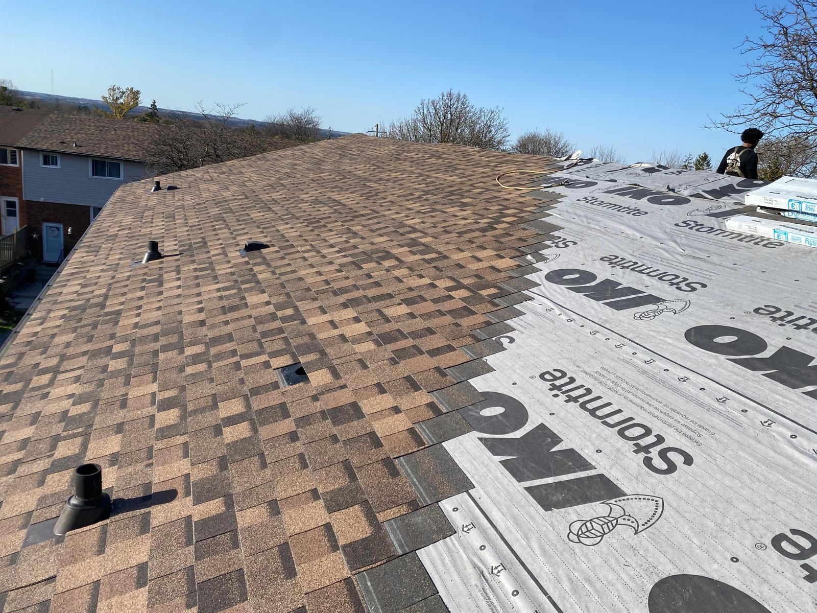 A roof with shingles being installed on it.