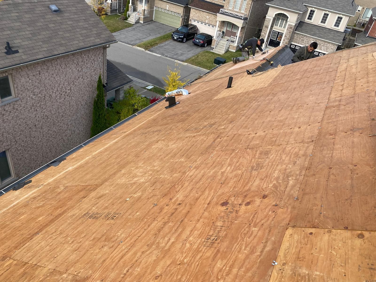 A group of people are working on a wooden roof.