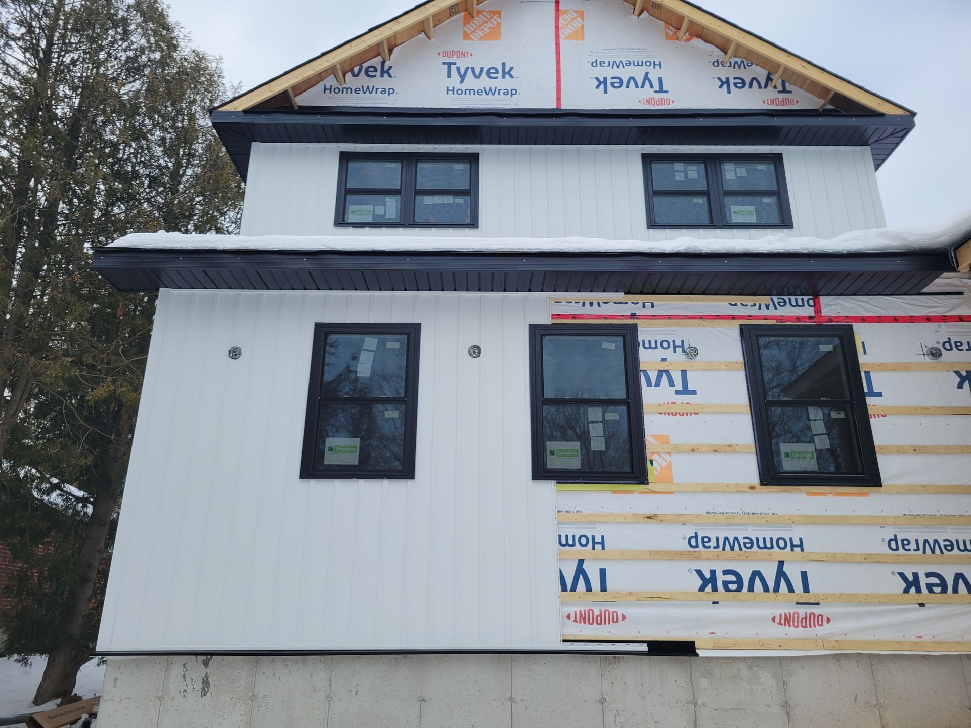 A white house with black windows is being built