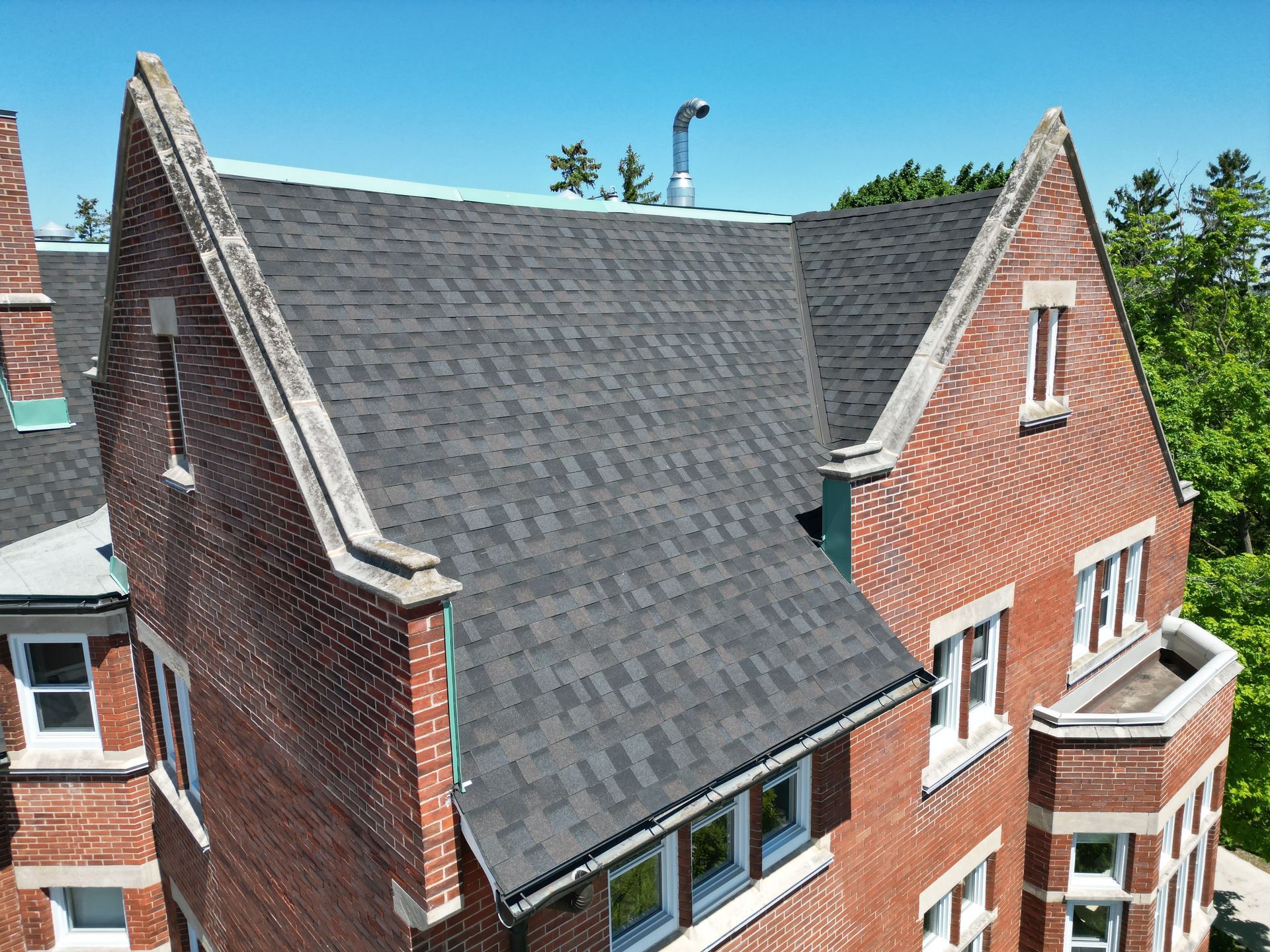 An aerial view of a brick building with a black roof
