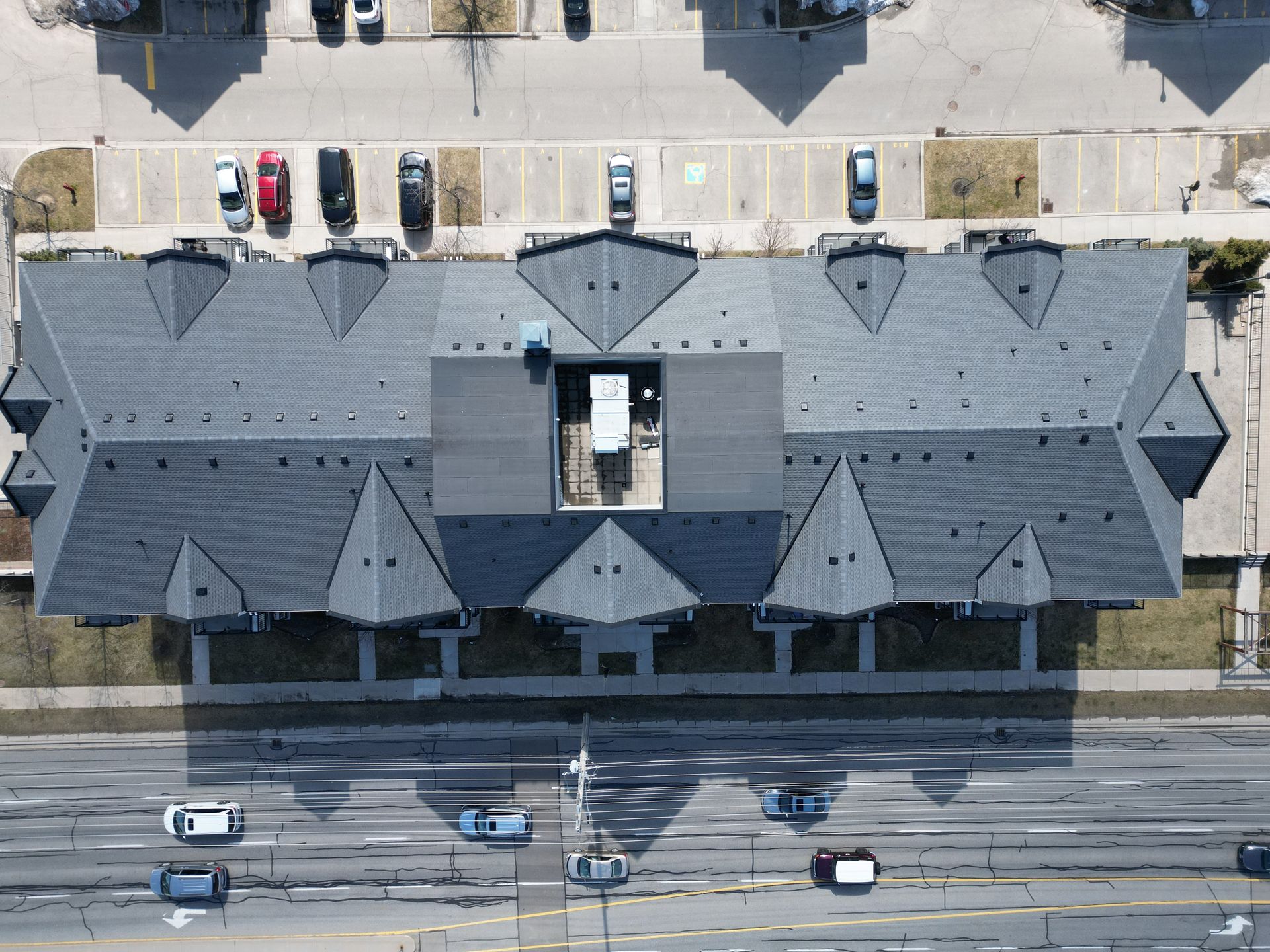 An aerial view of a building with cars parked in front of it