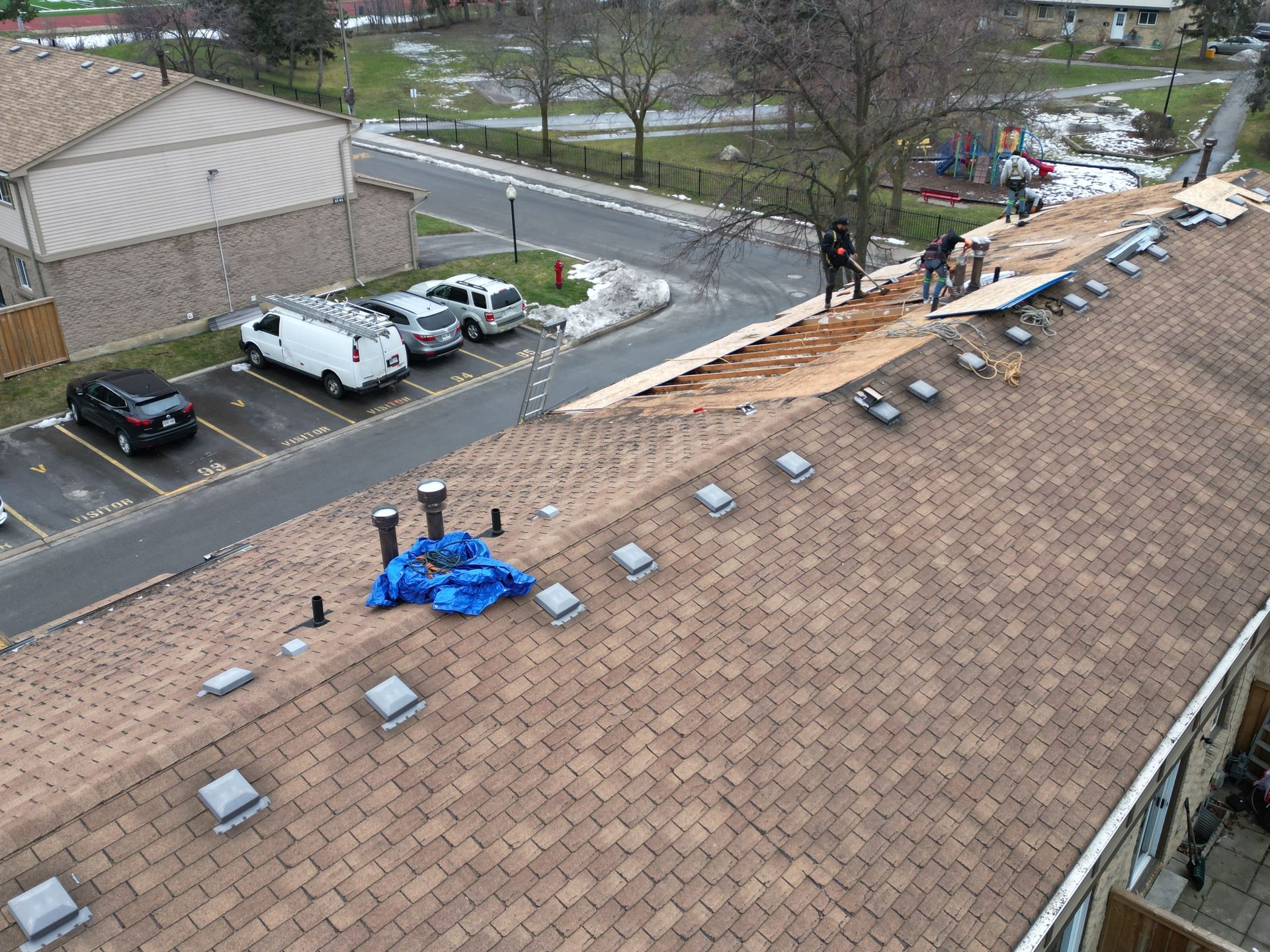 A group of people are working on the roof of a building.