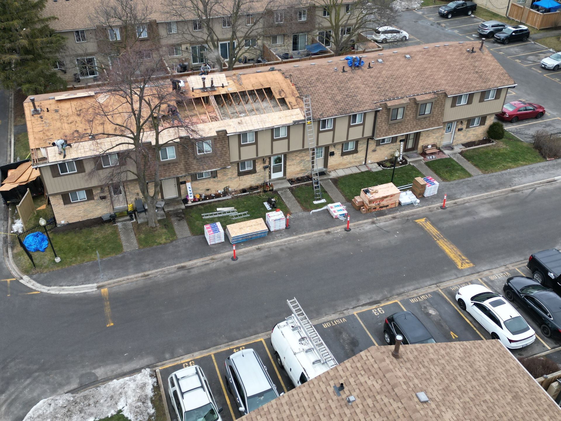 An aerial view of a building under construction with cars parked in front of it
