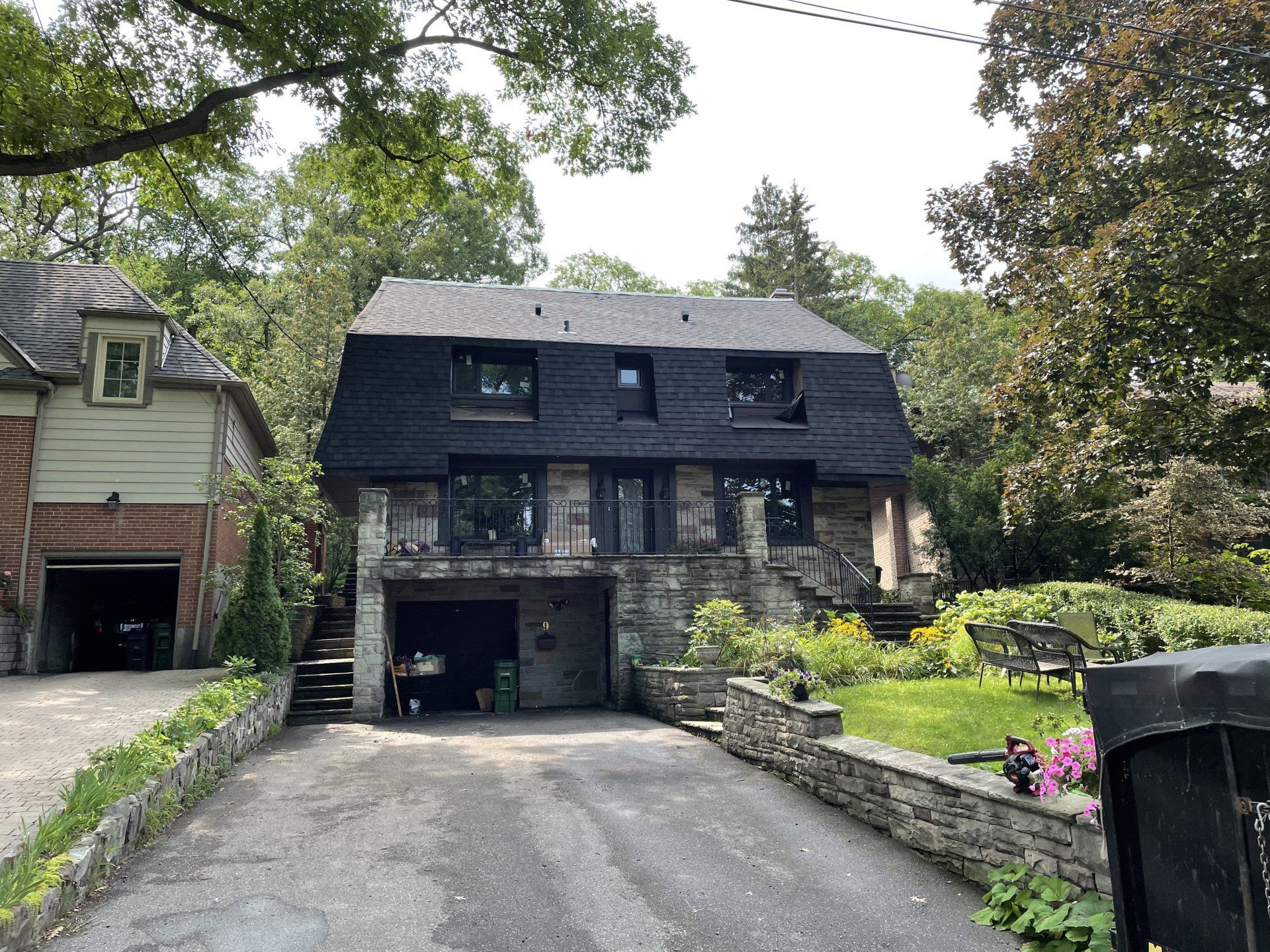 A large house with a black roof and a garage