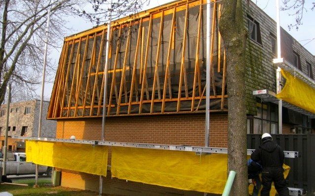 A man is standing in front of a building under construction