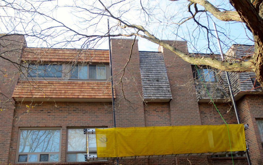 A brick building with a yellow banner hanging from the side