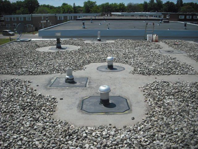 The roof of a building has a lot of gravel on it