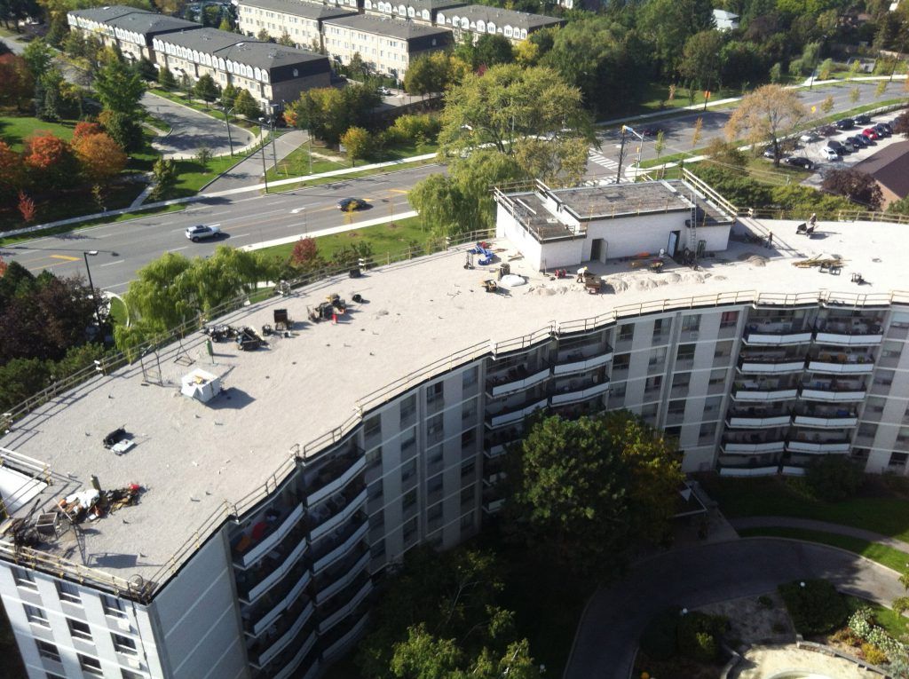 An aerial view of a large building with cars parked on the roof