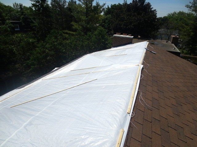 A brown roof with a white tarp on it