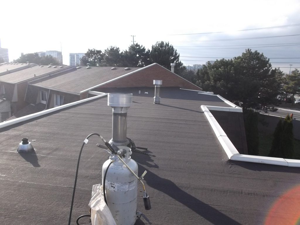 A propane tank is sitting on the roof of a building