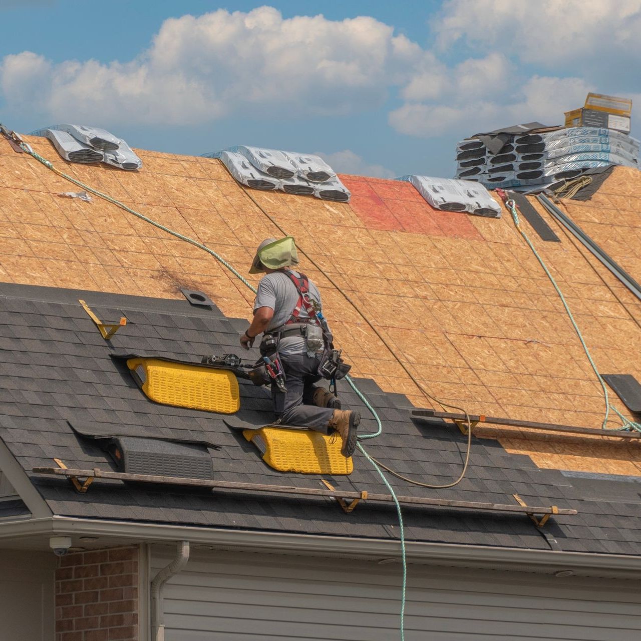 A man is working on the roof of a house.