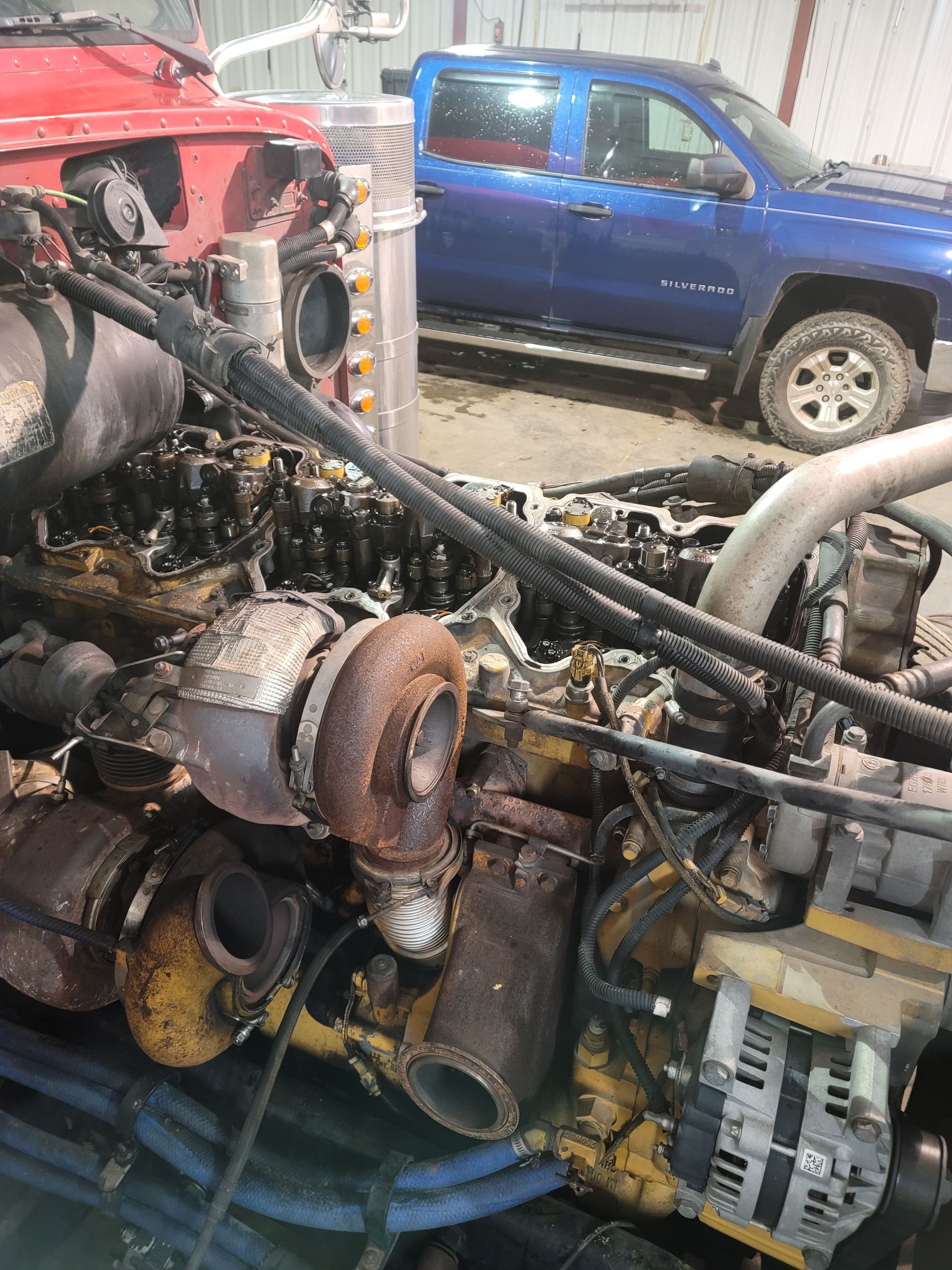 A close up of a machine with a blue bucket next to it.