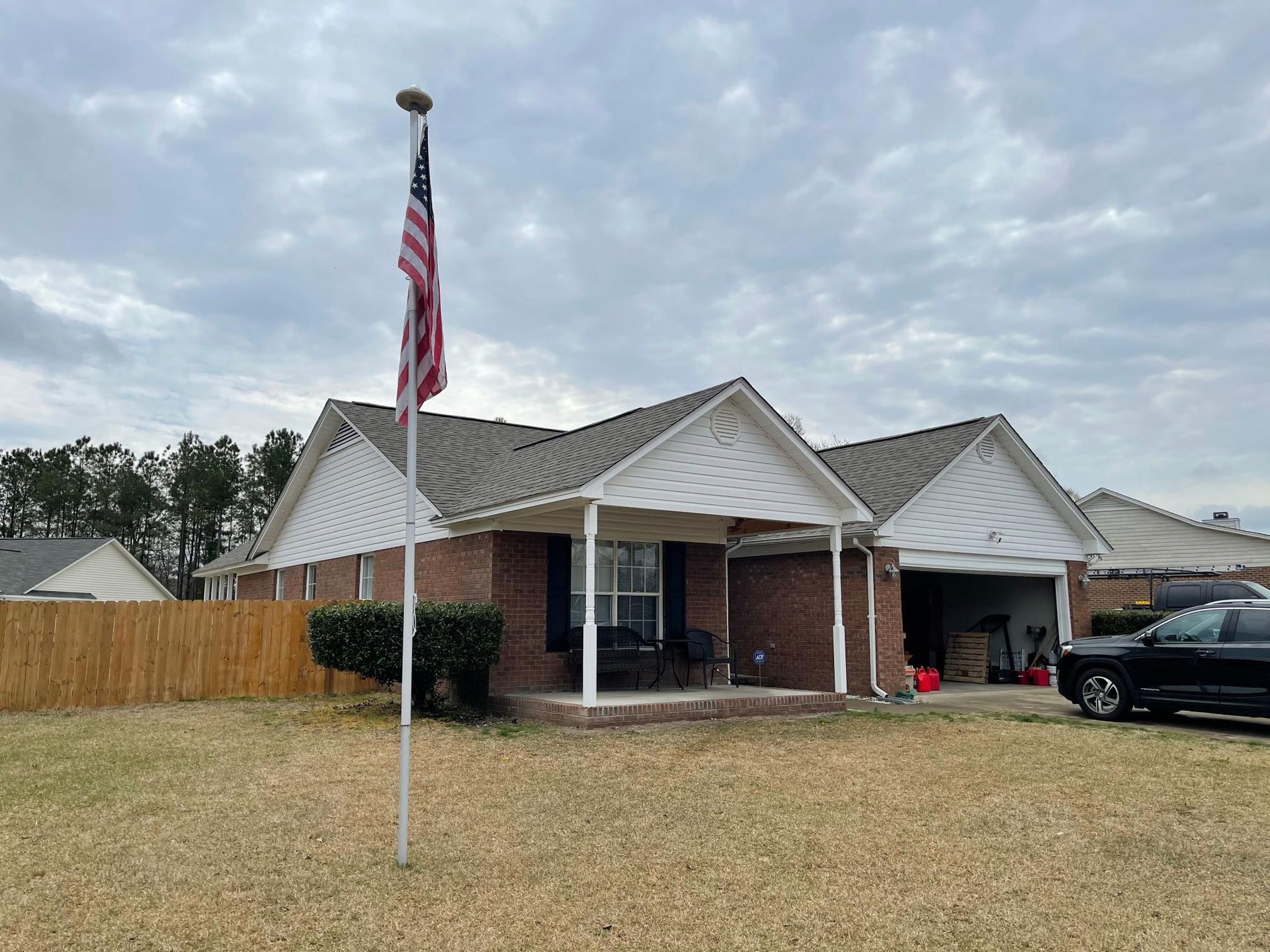 A brick house with an american flag flying in front of it.