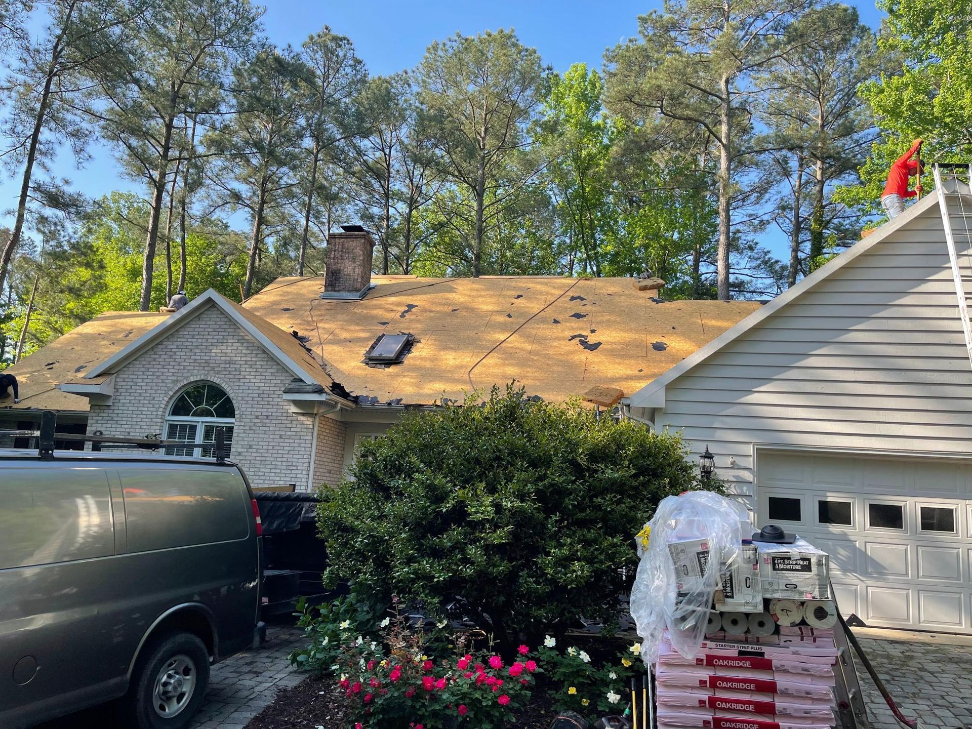 A man is working on the roof of a house.