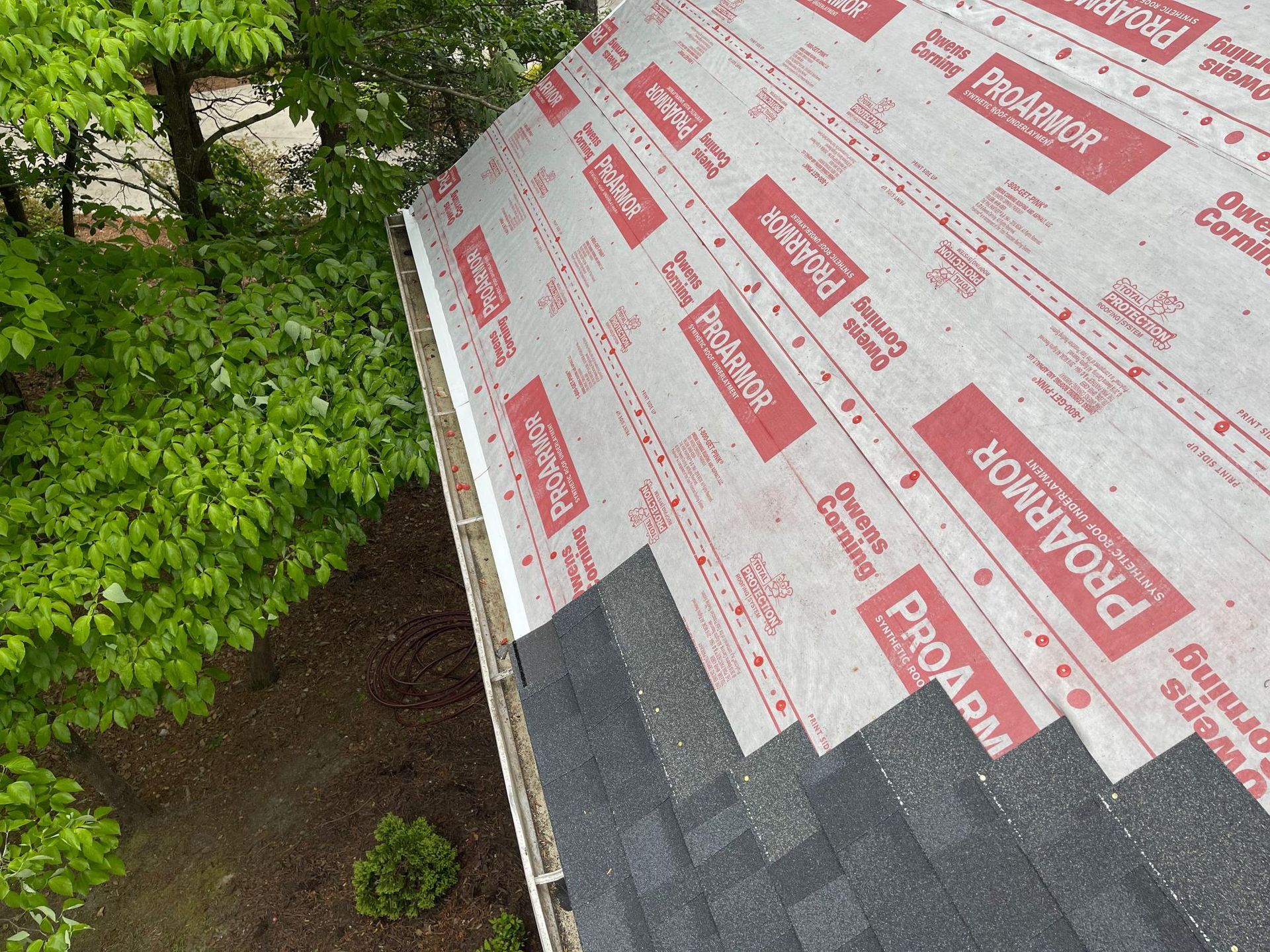 An aerial view of a roof with pro armor shingles on it