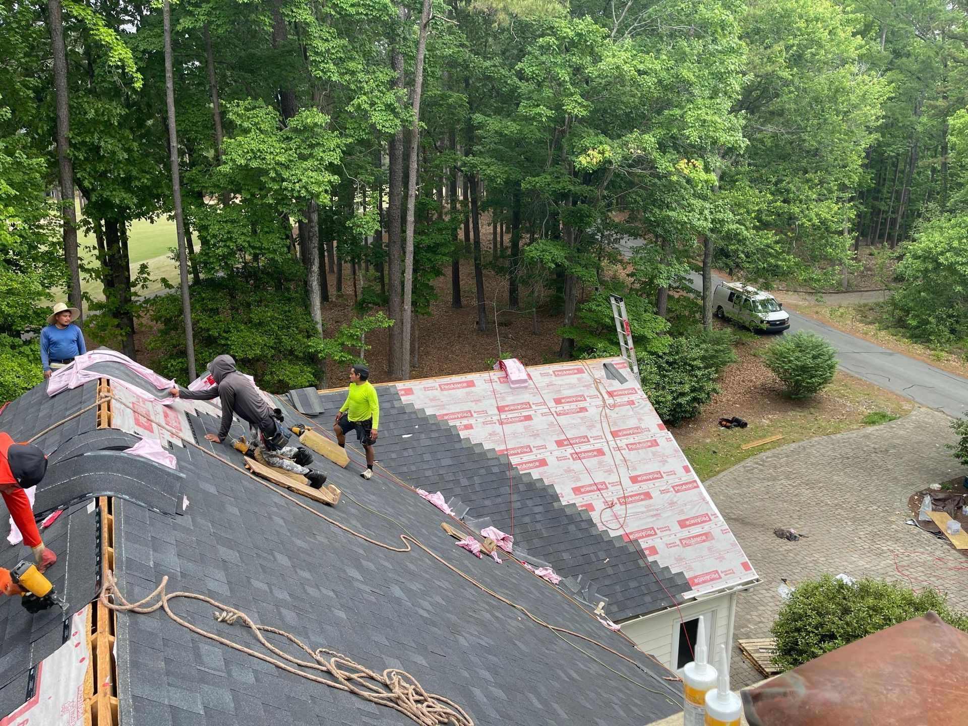 A group of people are working on the roof of a house.