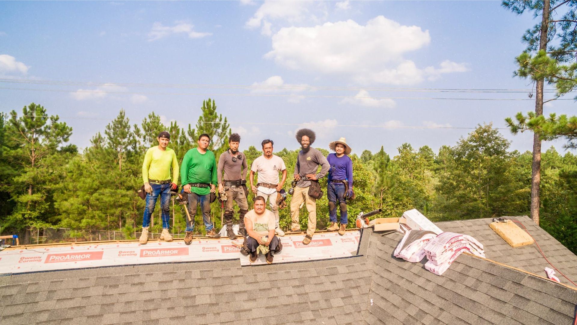 A group of people are standing on top of a roof.
