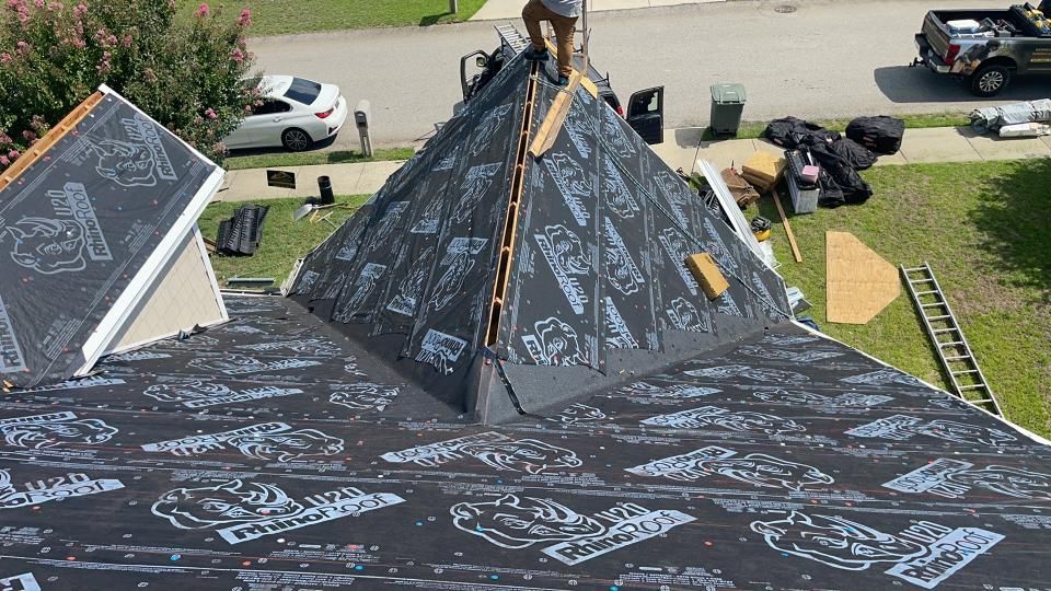 A man is working on the roof of a house.