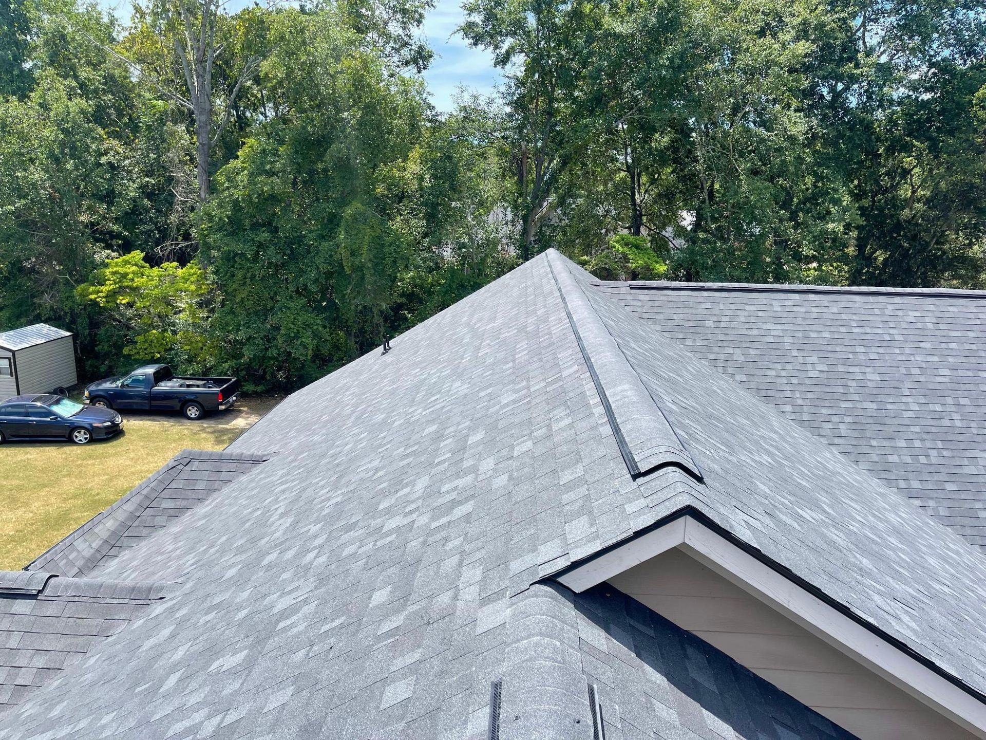 An aerial view of a roof with trees in the background.