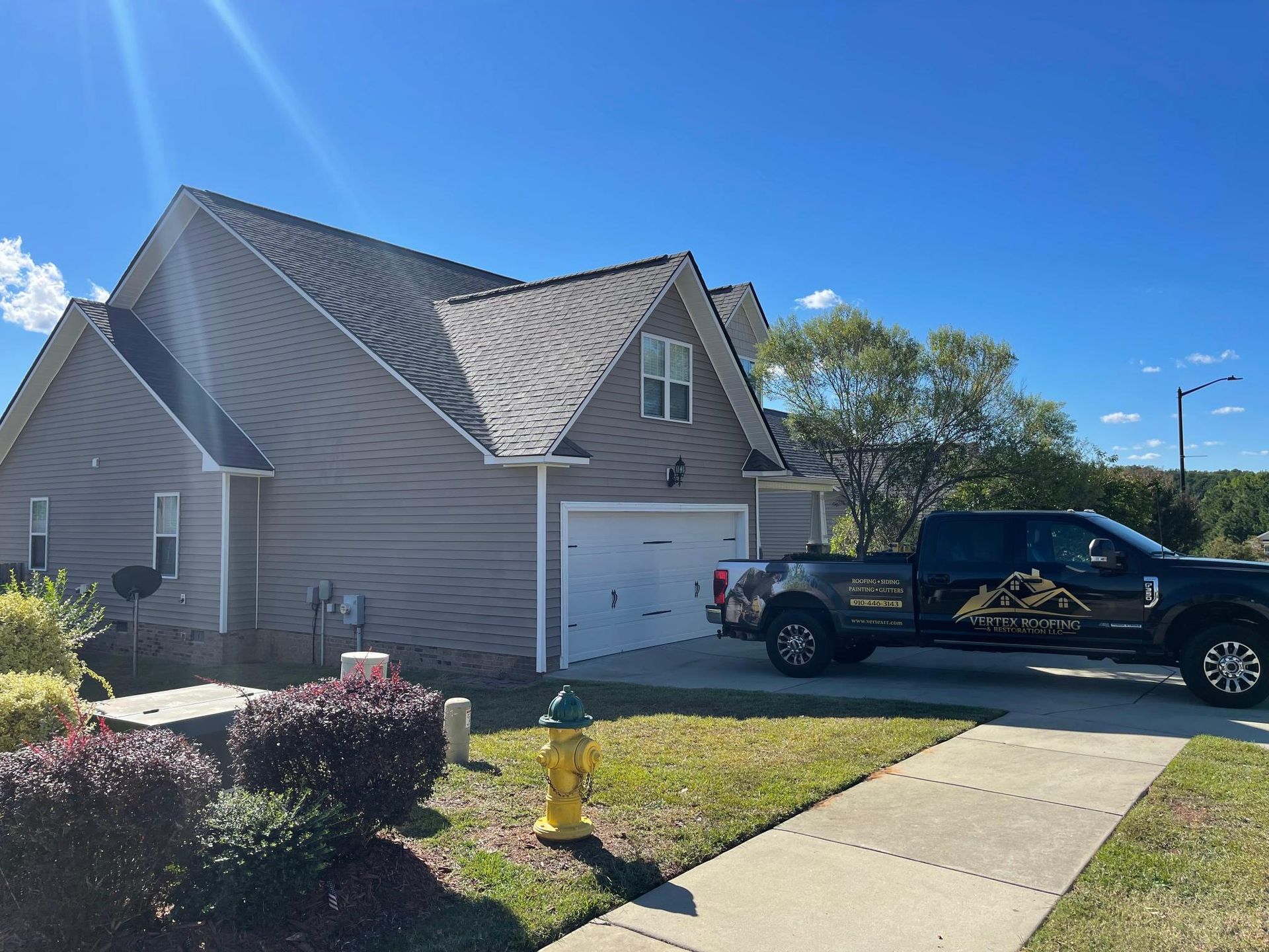 A black truck is parked in front of a house.