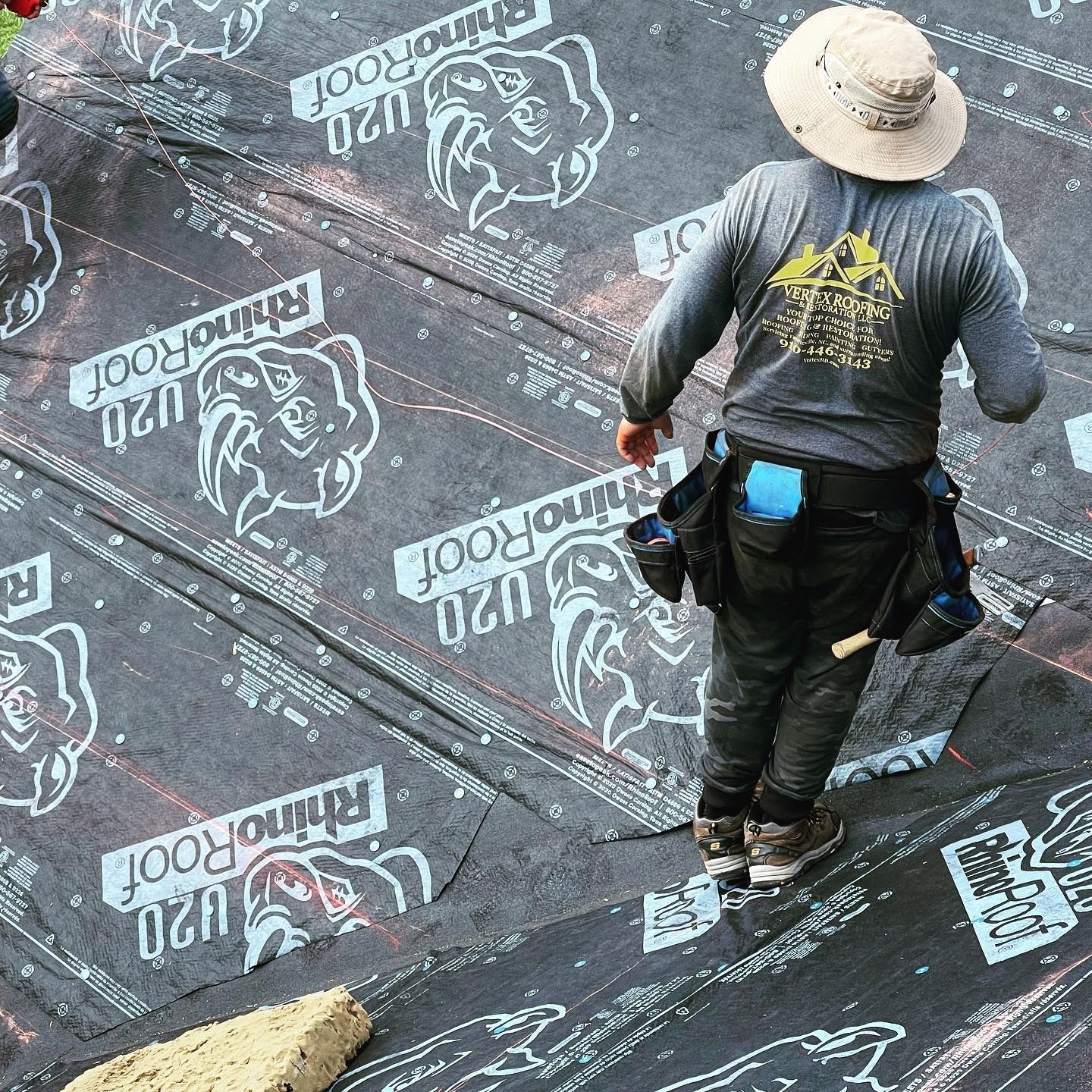 A man wearing a hat is standing on a rhino roof