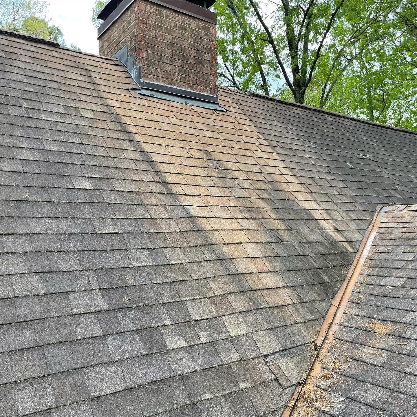 A close up of a roof with a chimney on top of it.