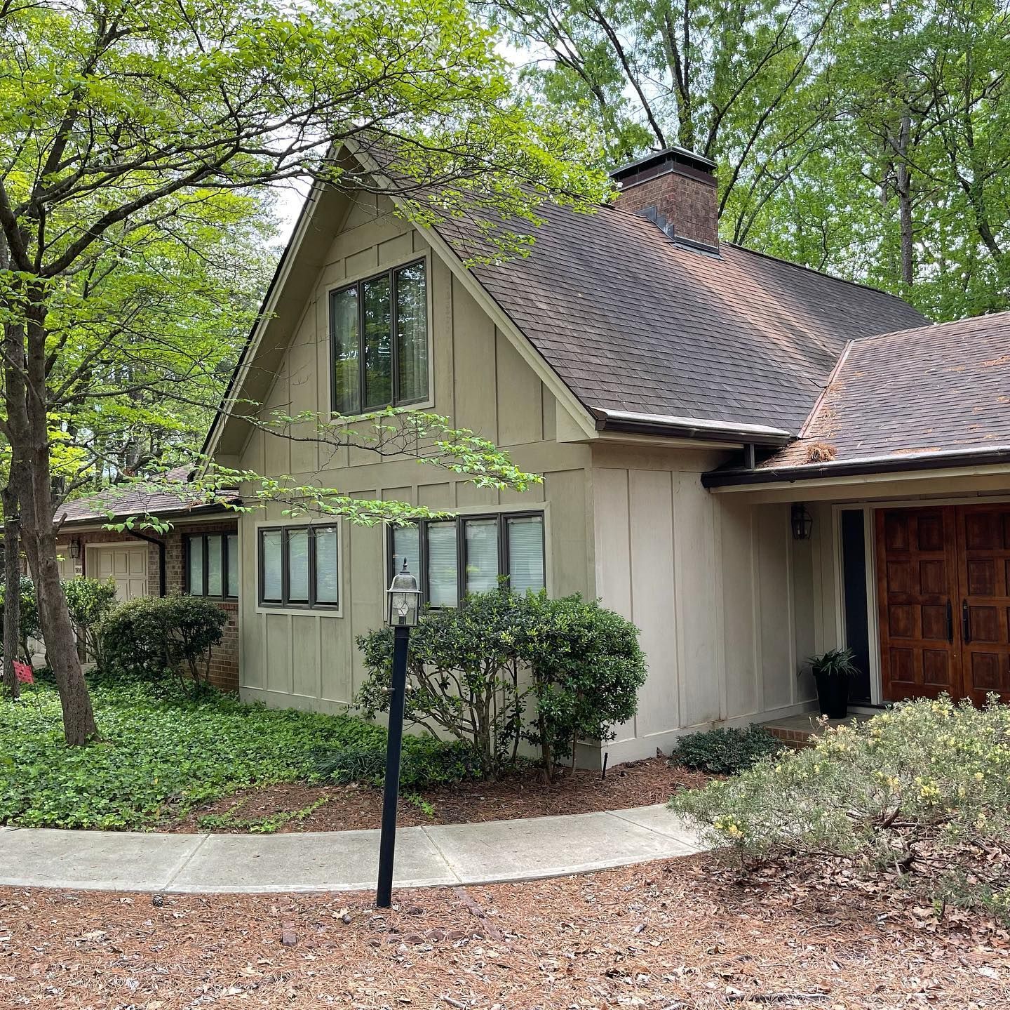 A house with a brown roof is surrounded by trees