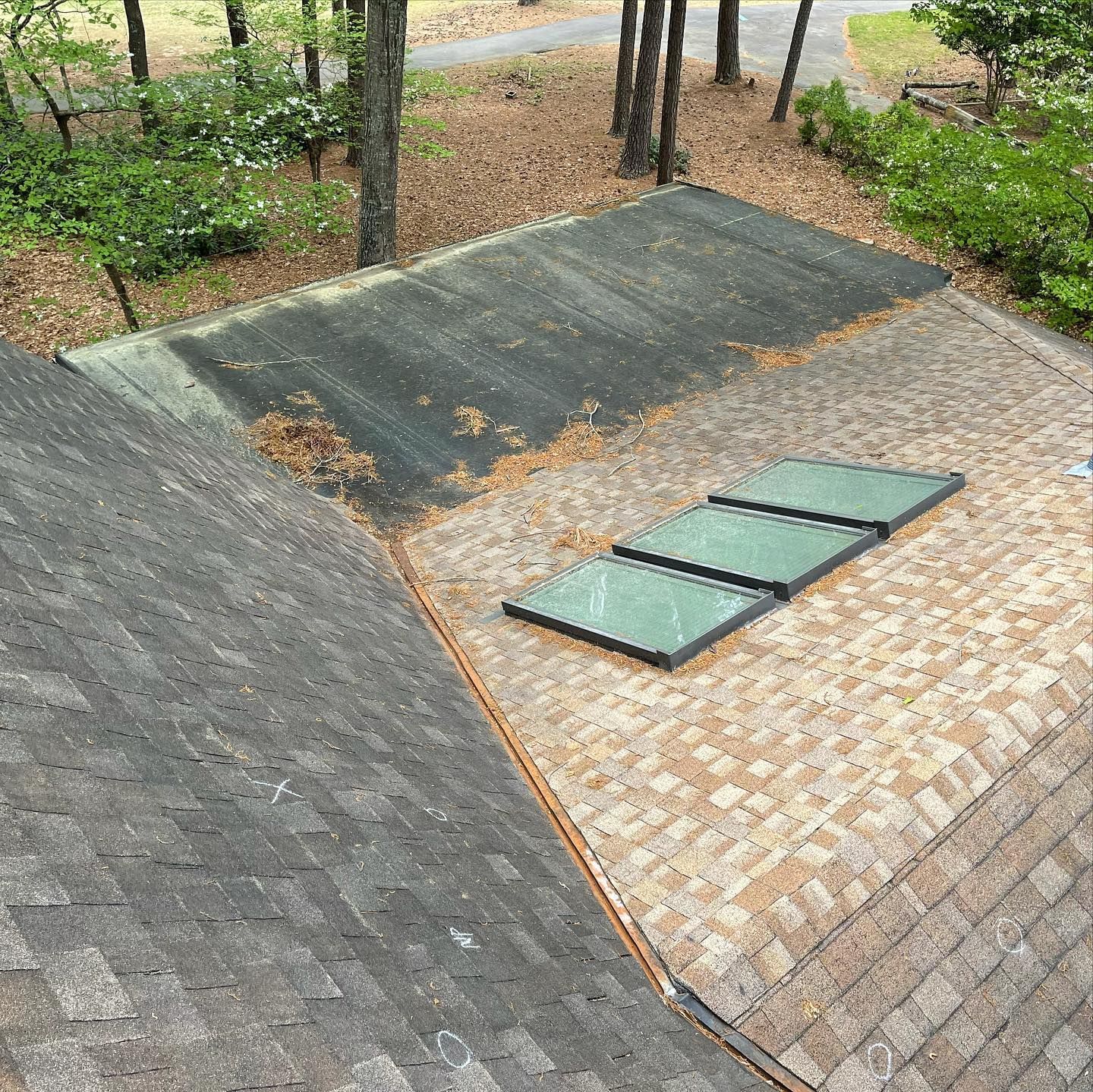 An aerial view of a roof with two skylights on it.