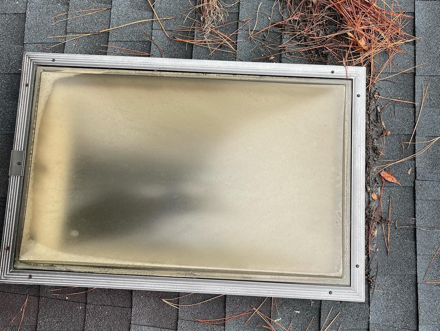 A skylight is sitting on top of a roof.