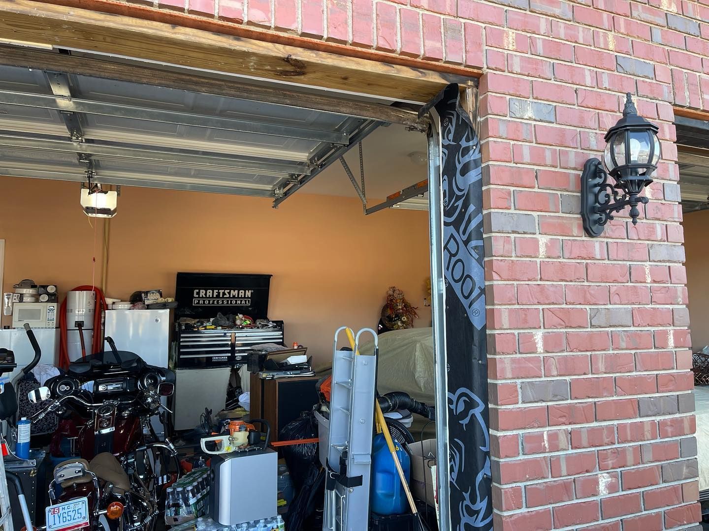 A garage filled with lots of junk and a brick wall.