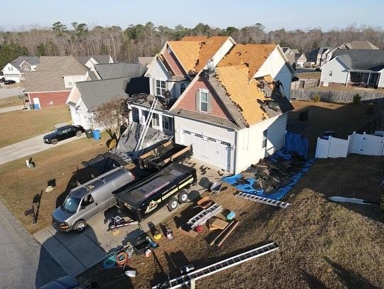 An aerial view of a house under construction in a residential neighborhood.