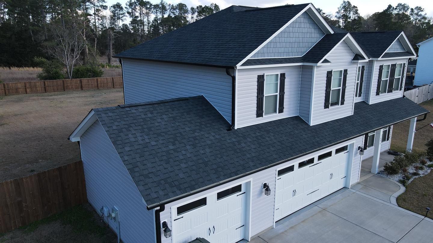 A white house with black shutters and a black roof