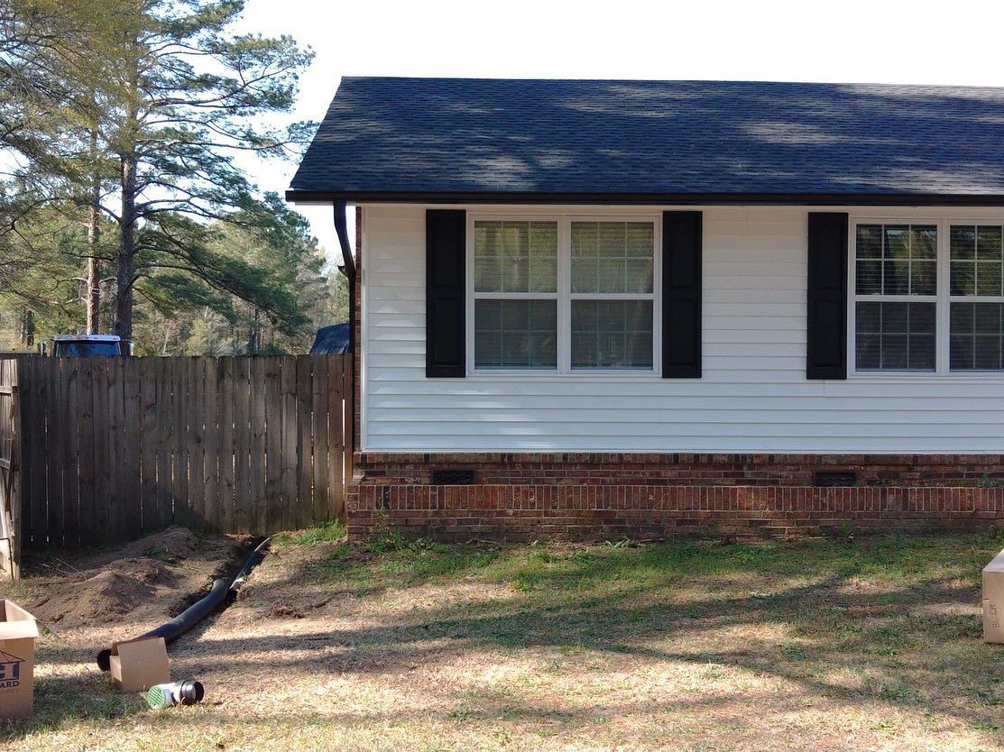 A small white house with black shutters and a blue roof