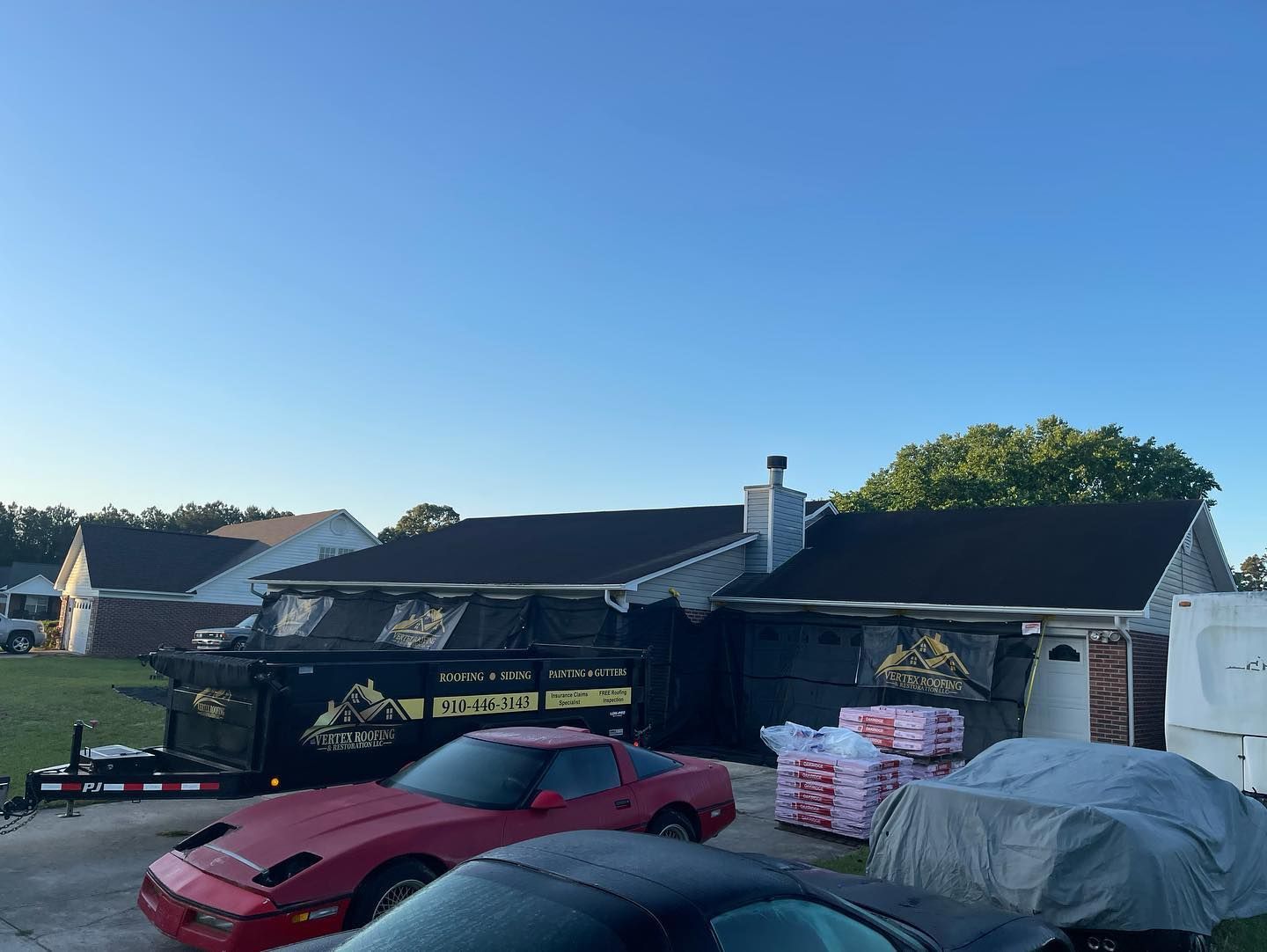 A red car is parked in front of a house.