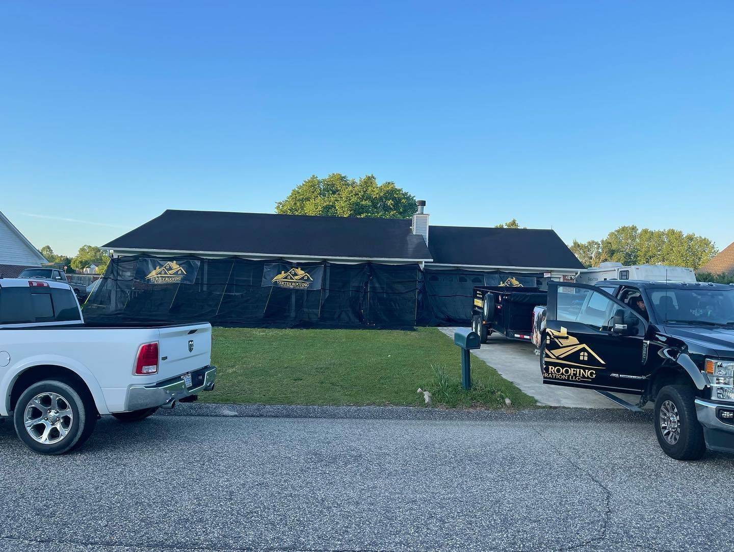Two trucks are parked in front of a house.