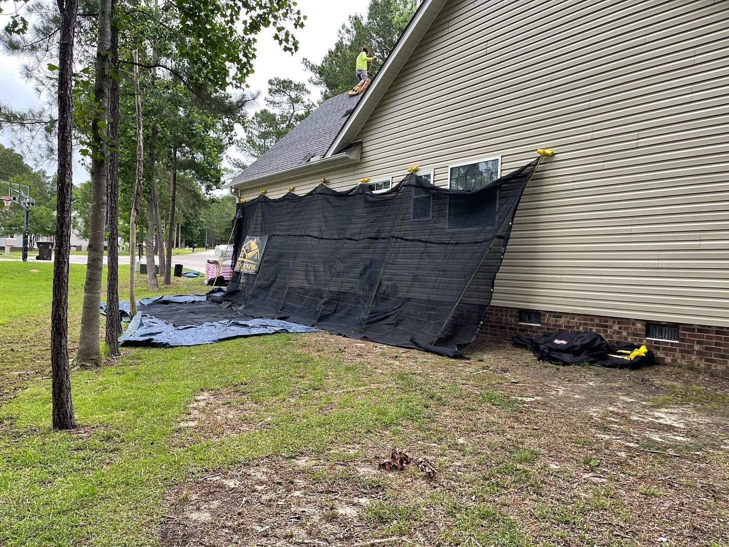 A large tarp is covering the side of a house.