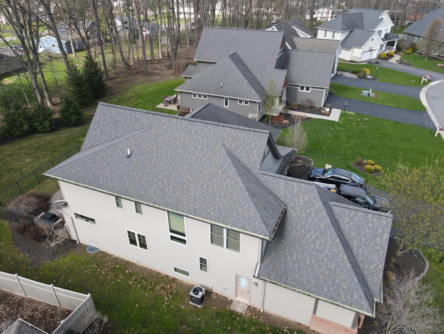 An aerial view of a house with a gray roof in a residential area.