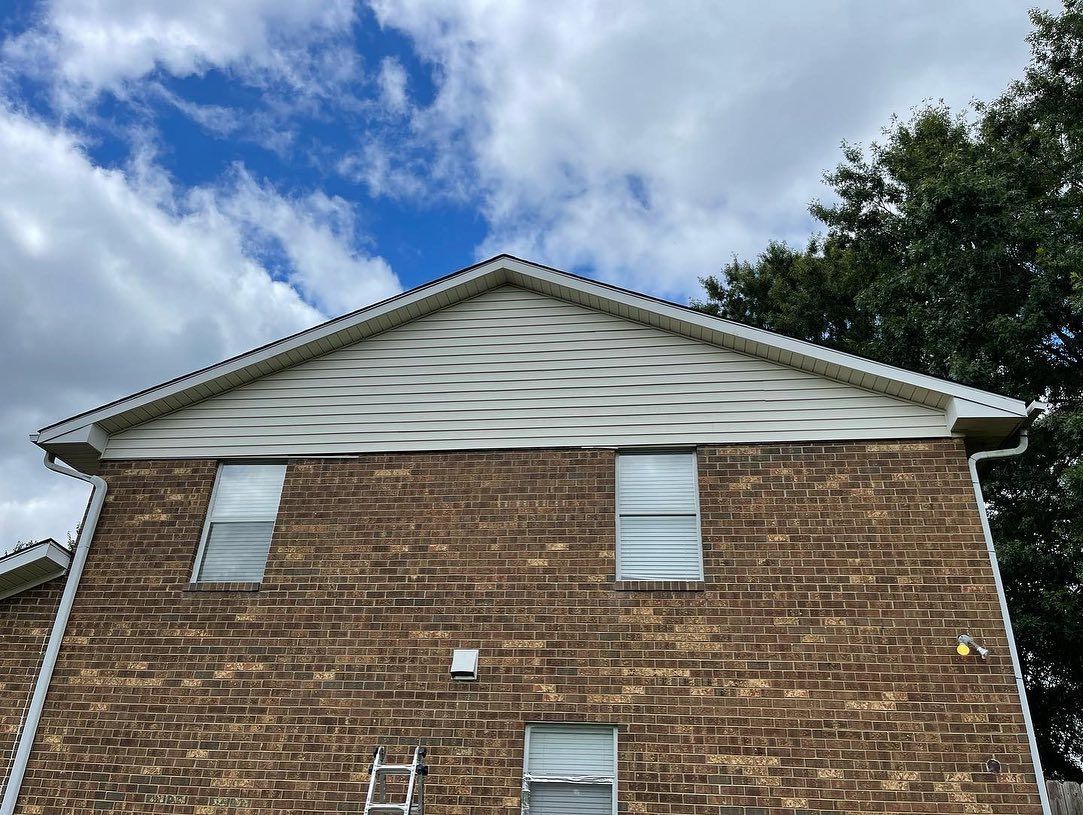 A brick house with a ladder on the side of it.