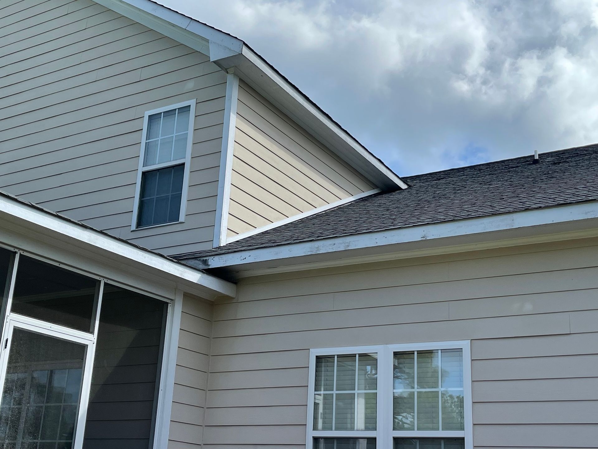 A house with a screened in porch and a roof.
