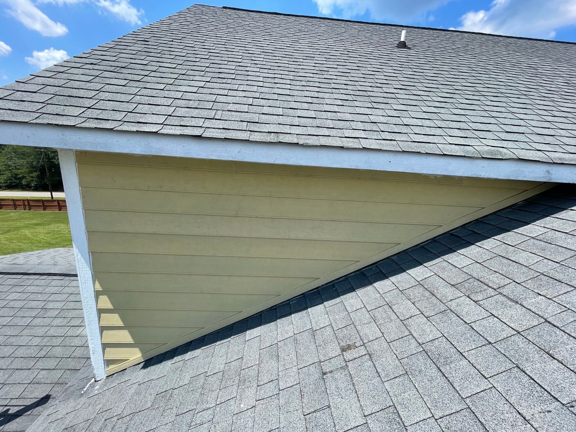 The roof of a house with a triangle shaped roof.