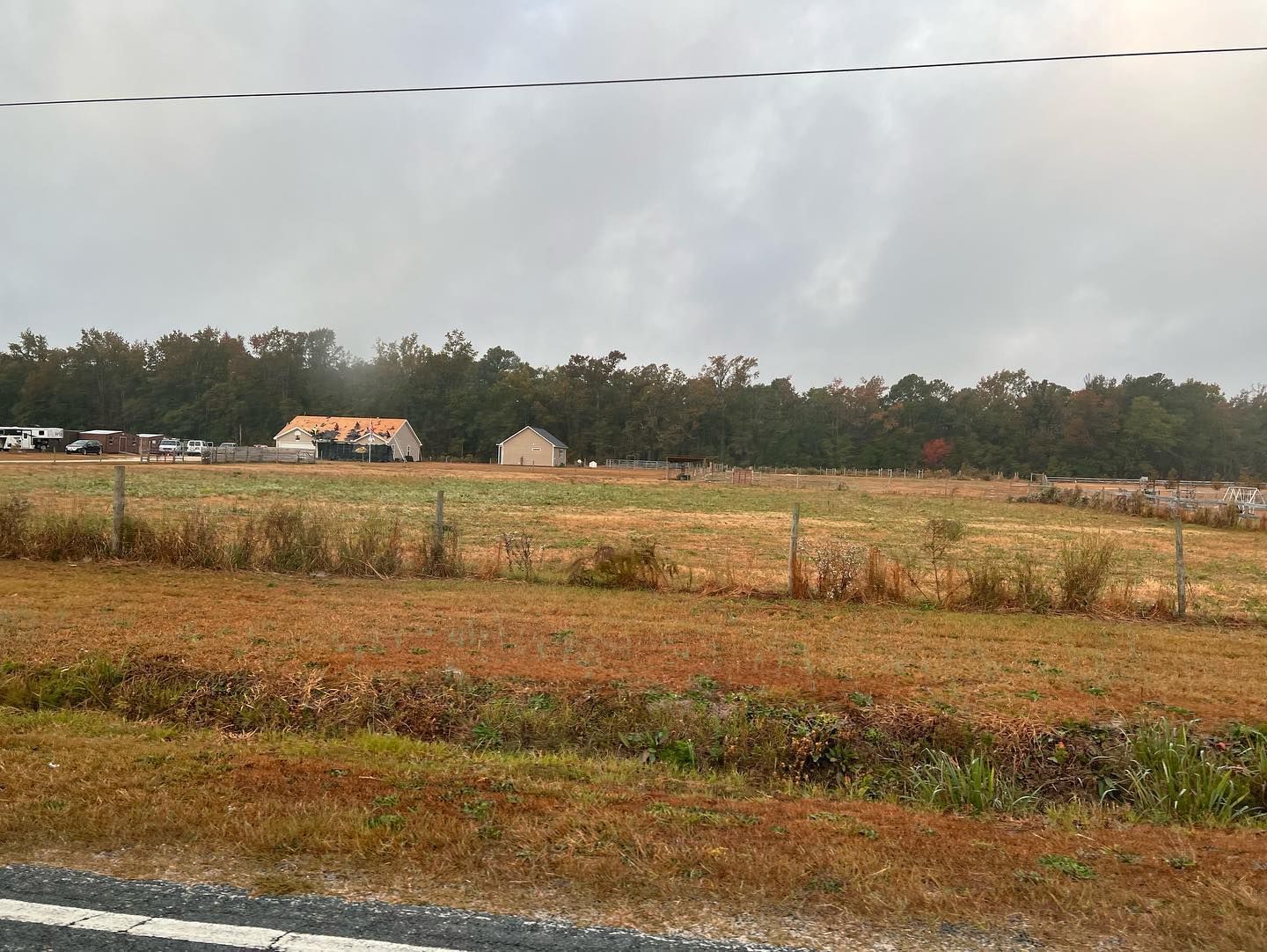 A fenced in field with a house in the background