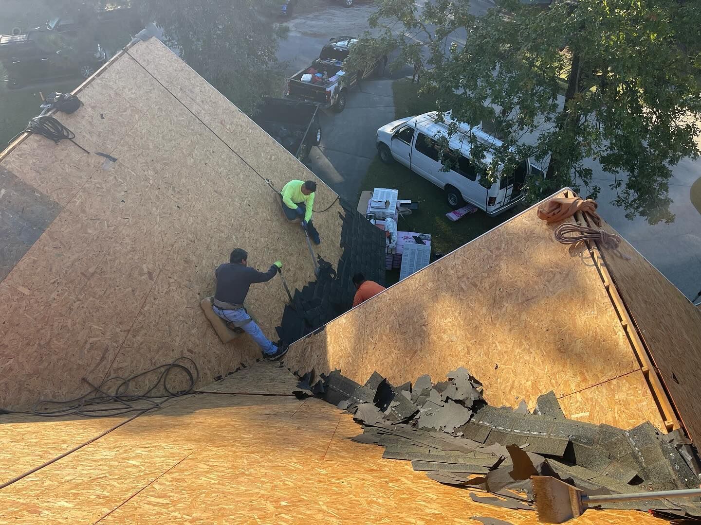 A group of people are working on the roof of a house.