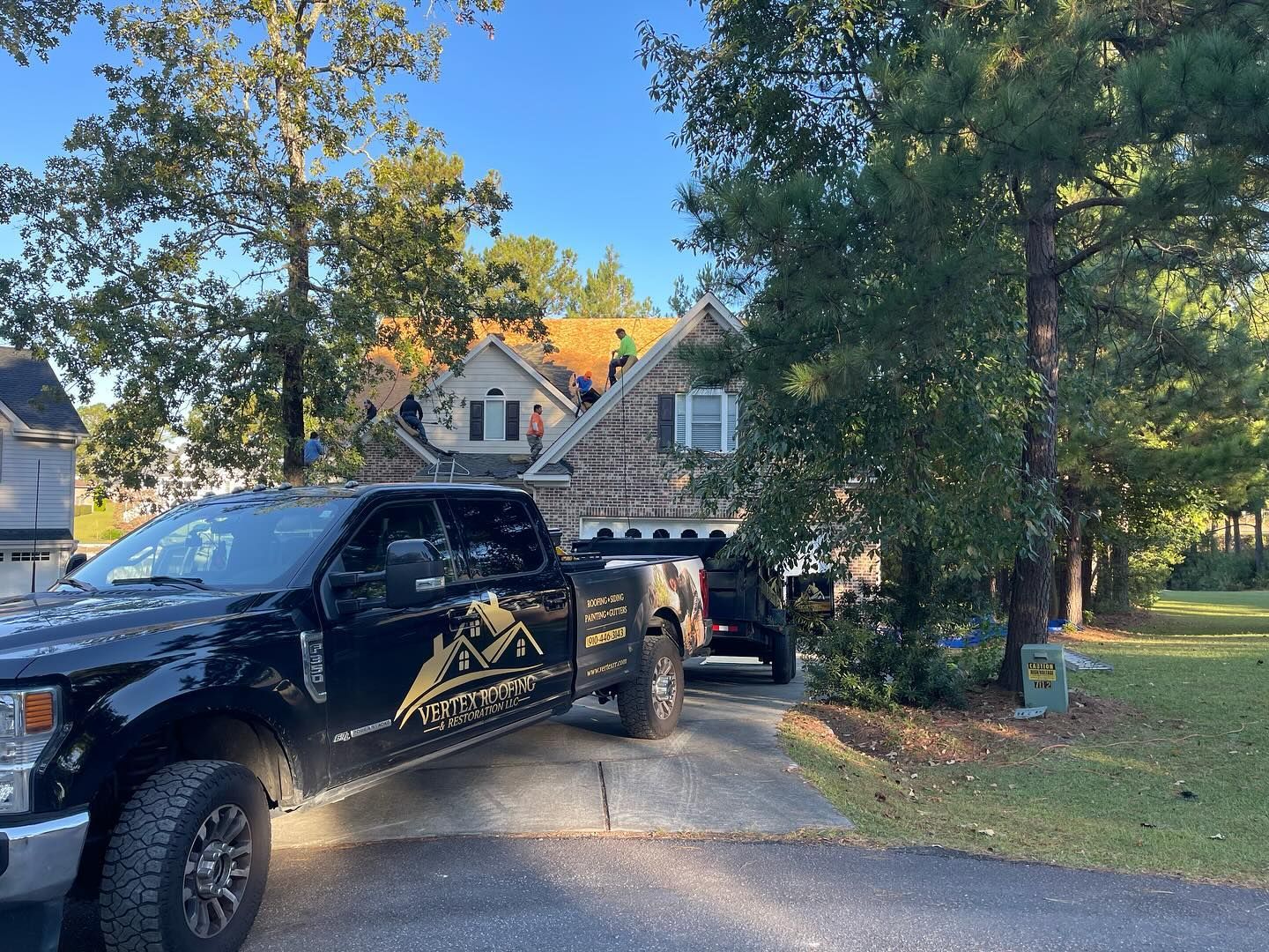 A black truck is parked in front of a house.