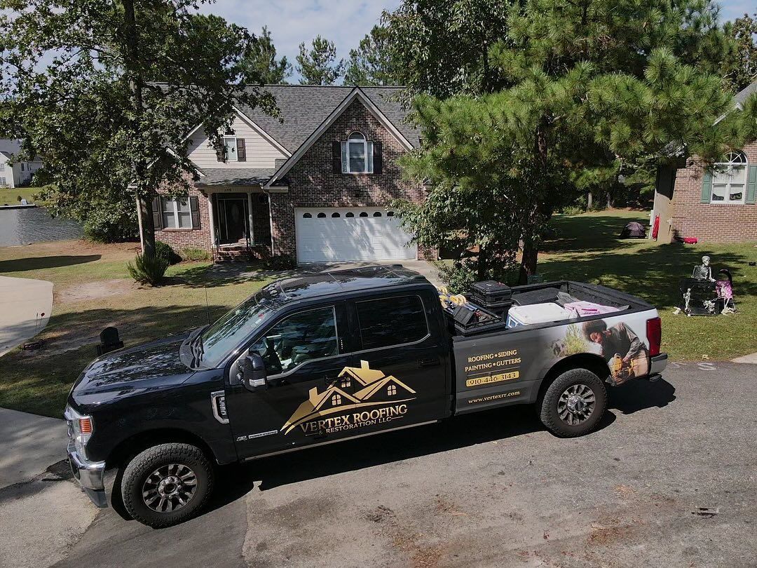 A black truck is parked in front of a house.