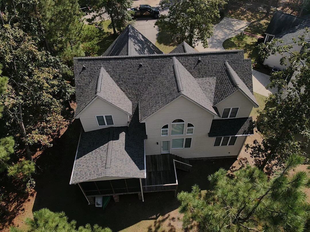 An aerial view of a large white house surrounded by trees.