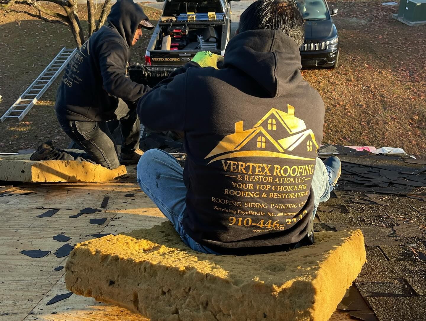 Two men are working on a roof and one of them is wearing a shirt that says vertex roofing.