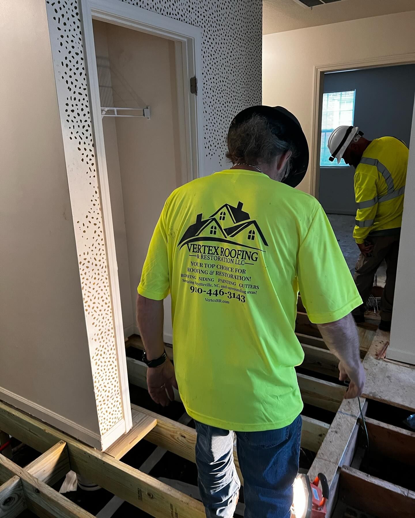 A man in a neon yellow shirt is standing in a room.