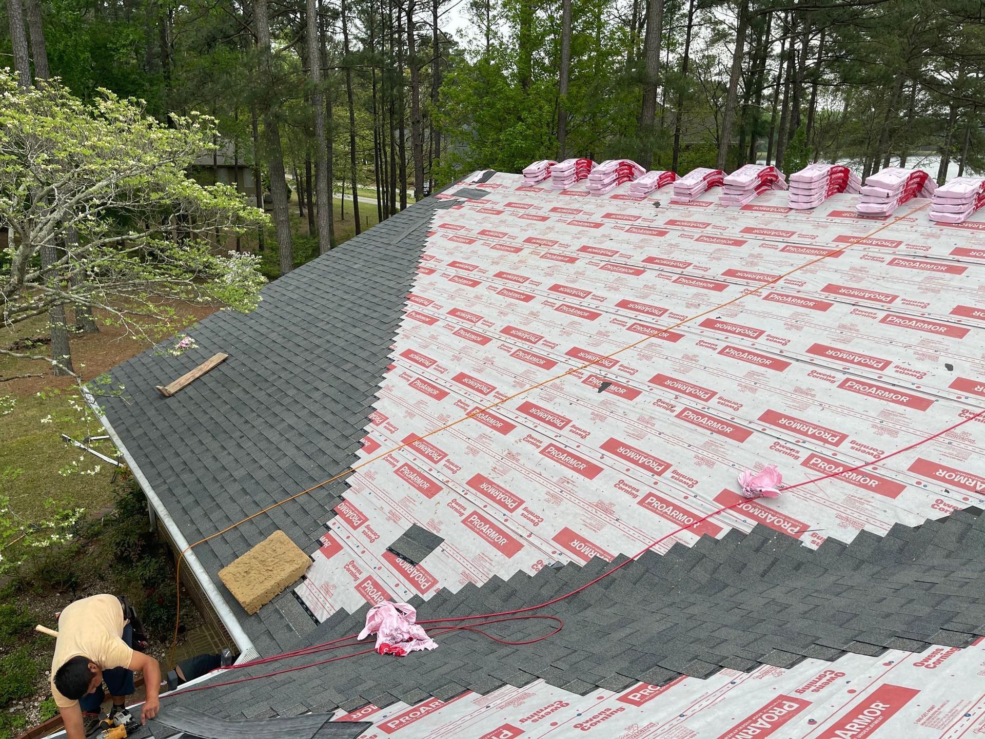 A man is working on the roof of a house.